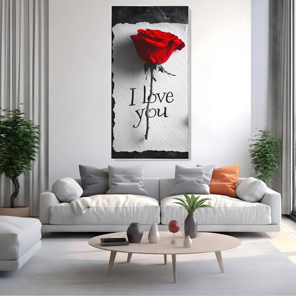 Tablou canvas cu tablou vertical cu trandafir rosu si mesaj, in rama de aluminiu argintiu, pe perete intr-un living